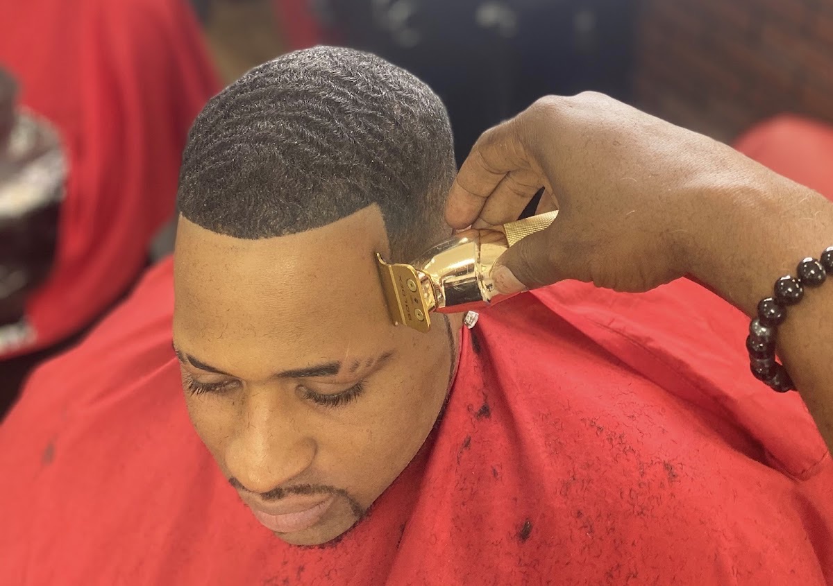 Barber giving a sharp clipper line-up at The HairPort Barbershop in Decatur, GA
